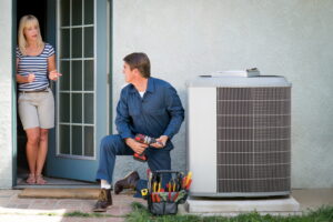 AC-repair-technician-working-on-outdoor-AC-unit